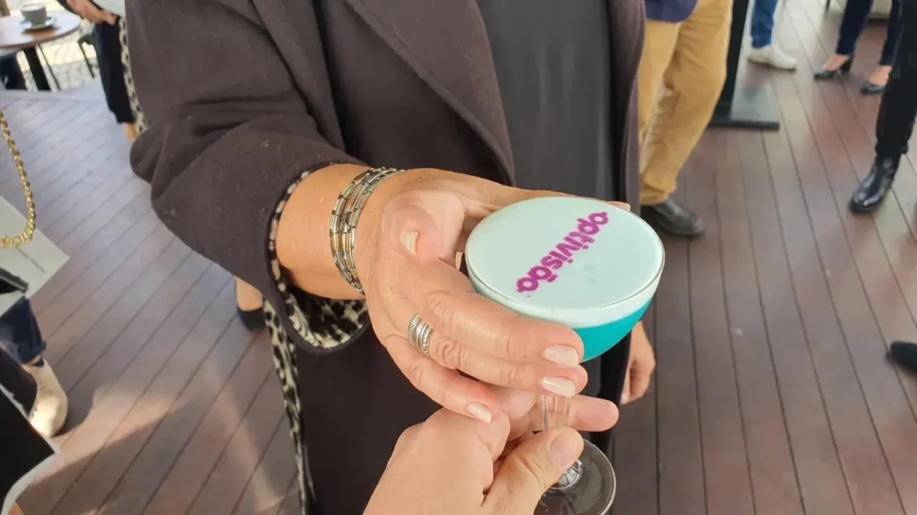 uma pessoa segurando um drink personalizado com o nome de uma marca